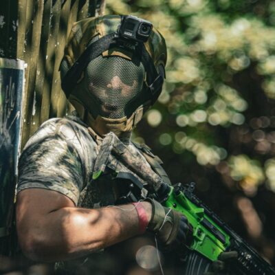 Man in Camouflage Clothing Holding a Paintball Gun