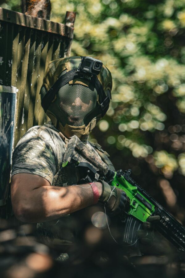 Man in Camouflage Clothing Holding a Paintball Gun